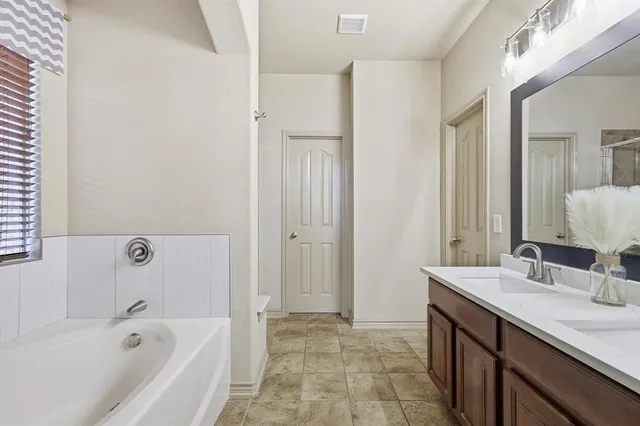 a bathroom with a tub sink and mirror