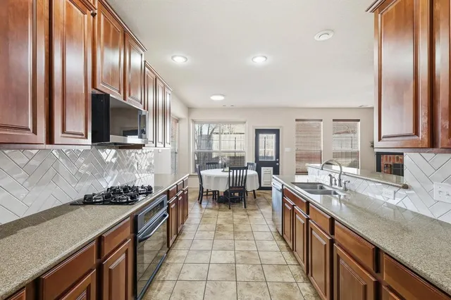 a kitchen with stainless steel appliances granite countertop a sink stove and cabinets