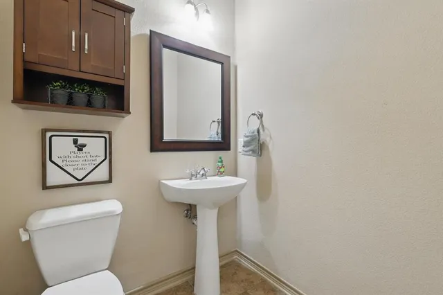 a bathroom with a toilet sink and mirror