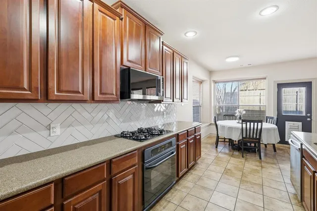 a kitchen with stainless steel appliances a stove a sink and cabinets