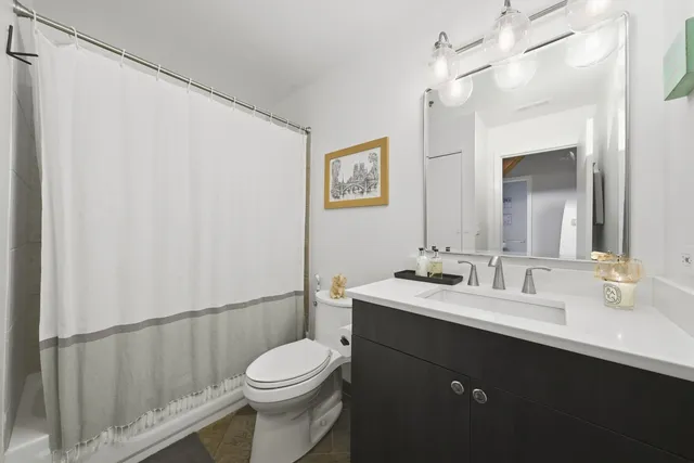 a bathroom with a sink a toilet a mirror and shower