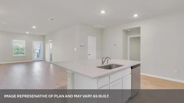 a view of kitchen island a sink wooden floor and a living room