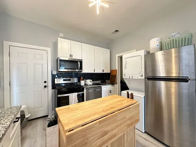 a kitchen with kitchen island a refrigerator sink and stove