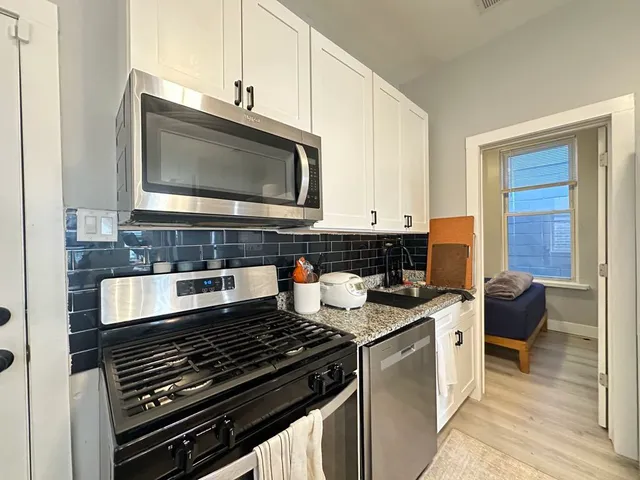 a kitchen with stainless steel appliances granite countertop a stove and a microwave