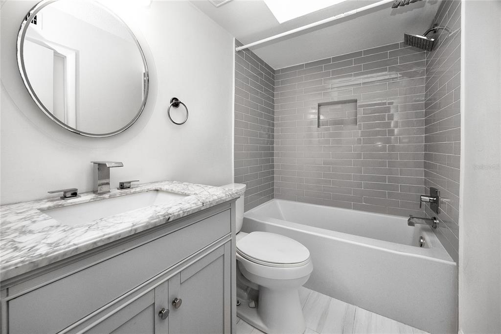 2207 Belleair Road, Unit B4 Clearwater, FL 33764 - Photo 26 of 37 a bathroom with a granite countertop sink a toilet and bathtub