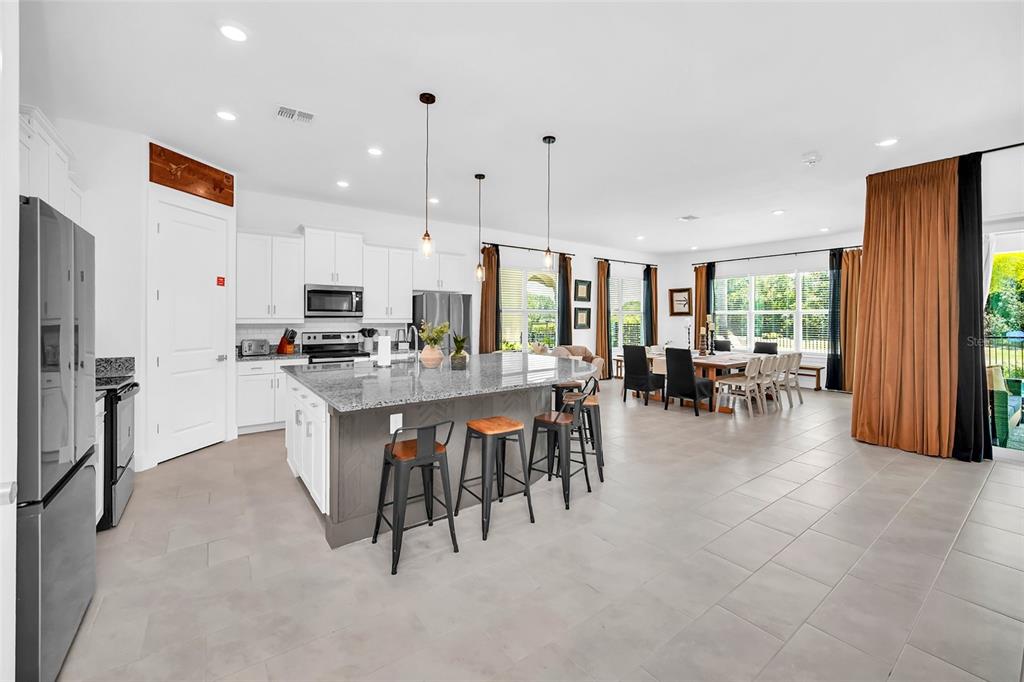 1213 Radiant Street Reunion, FL 34747 - Photo 25 of 84 a kitchen with kitchen island granite countertop lots of counter top space and stainless steel appliances