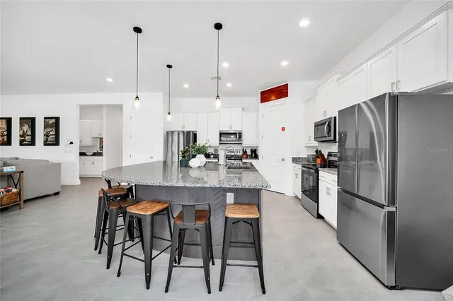 a bathroom with a granite countertop bathtub a sink and a shower