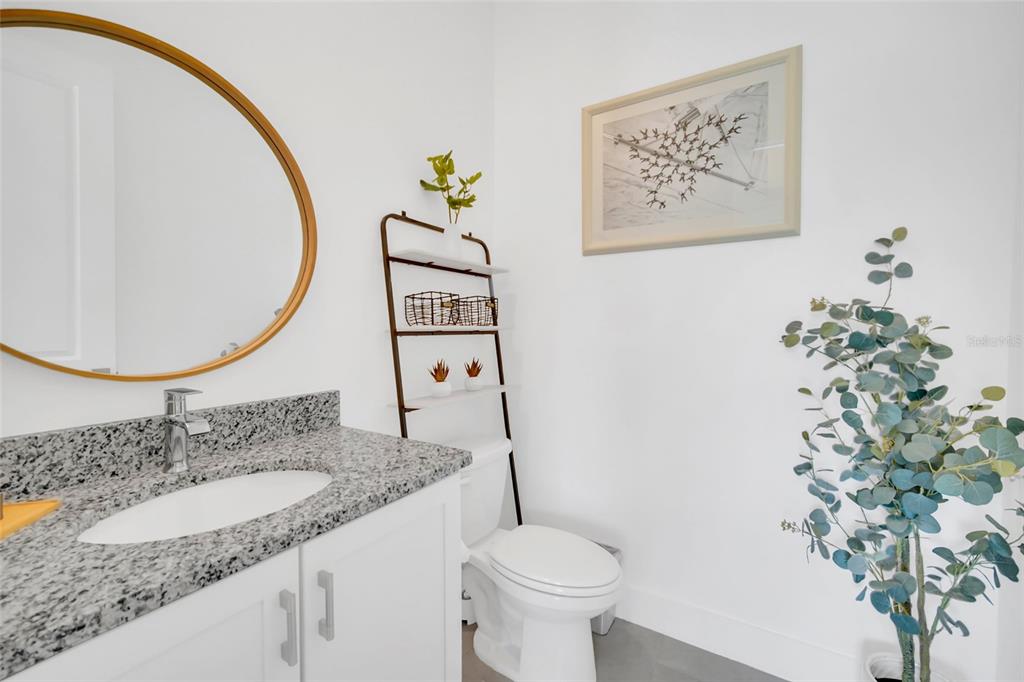 1213 Radiant Street Reunion, FL 34747 - Photo 36 of 84 a bathroom with a granite countertop sink a toilet and a mirror