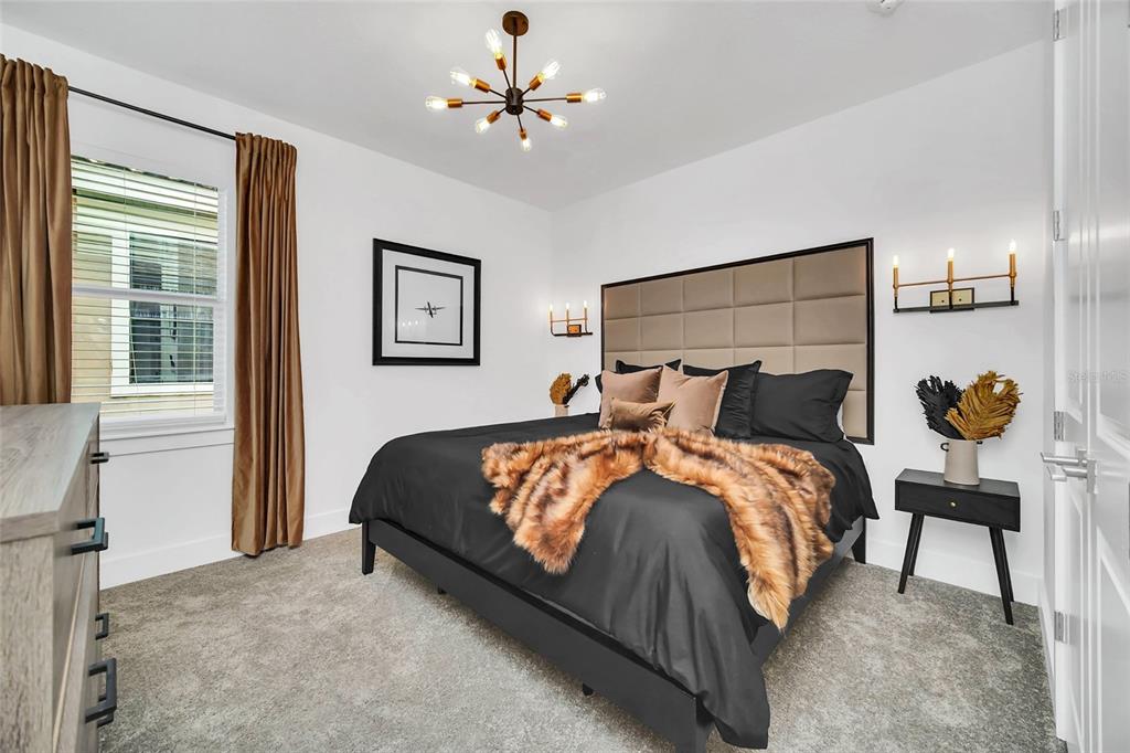 1213 Radiant Street Reunion, FL 34747 - Photo 55 of 84 a bedroom with a bed and a chandelier