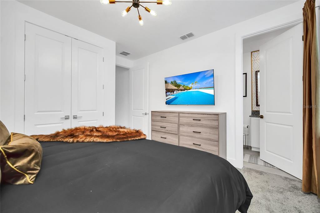 1213 Radiant Street Reunion, FL 34747 - Photo 56 of 84 a bedroom with a bed and a tv on the dresser