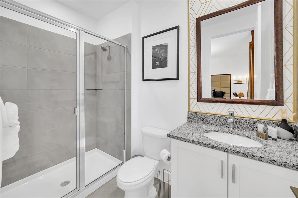 1213 Radiant Street Reunion, FL 34747 - Photo 57 of 84 a bathroom with a granite countertop sink toilet and shower