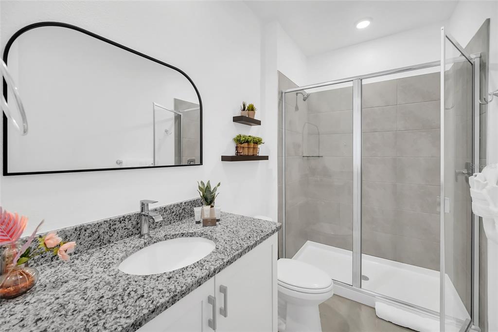 1213 Radiant Street Reunion, FL 34747 - Photo 60 of 84 a bathroom with a granite countertop sink toilet and shower