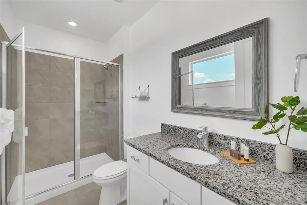 1213 Radiant Street Reunion, FL 34747 - Photo 63 of 84 a bathroom with a granite countertop sink toilet and shower