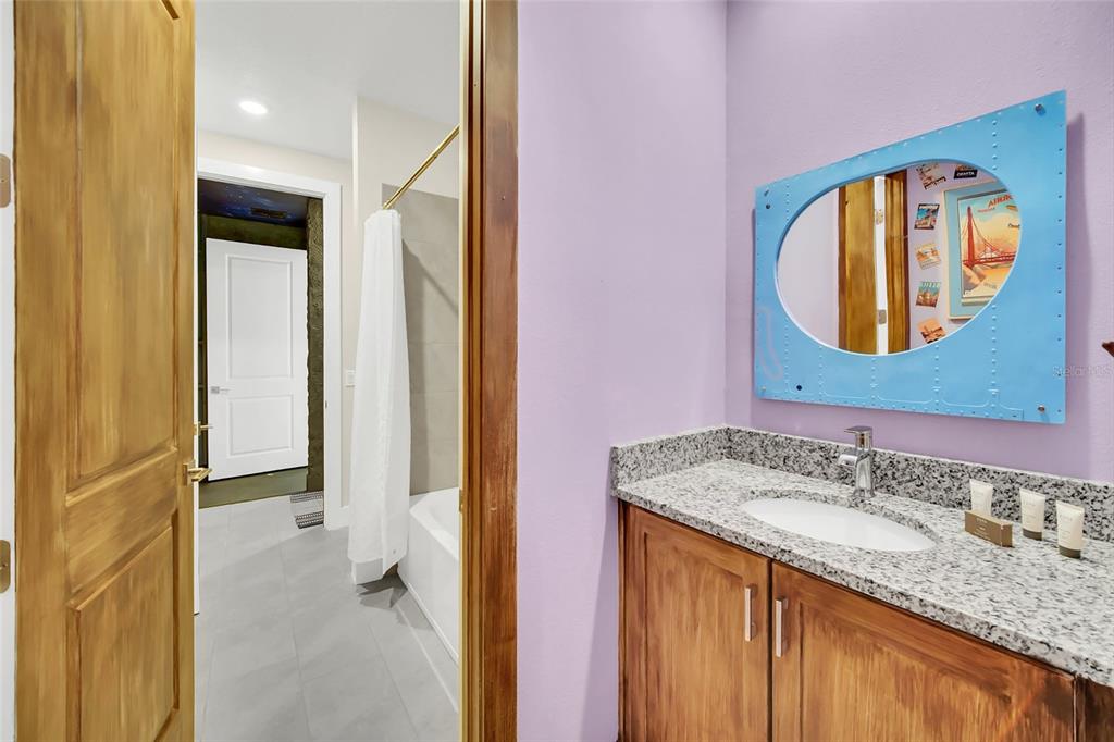 1213 Radiant Street Reunion, FL 34747 - Photo 64 of 84 a bathroom with a granite countertop sink a mirror and a shower