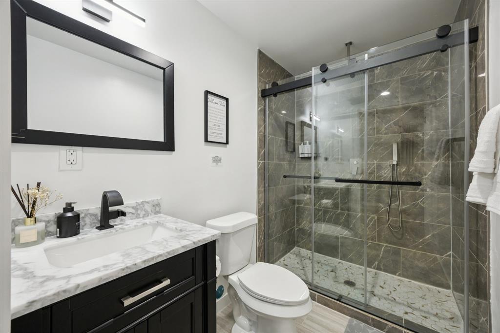 907 Bayonne Street Dallas, TX 75212 - Photo 25 of 38 a bathroom with a granite countertop sink toilet and shower