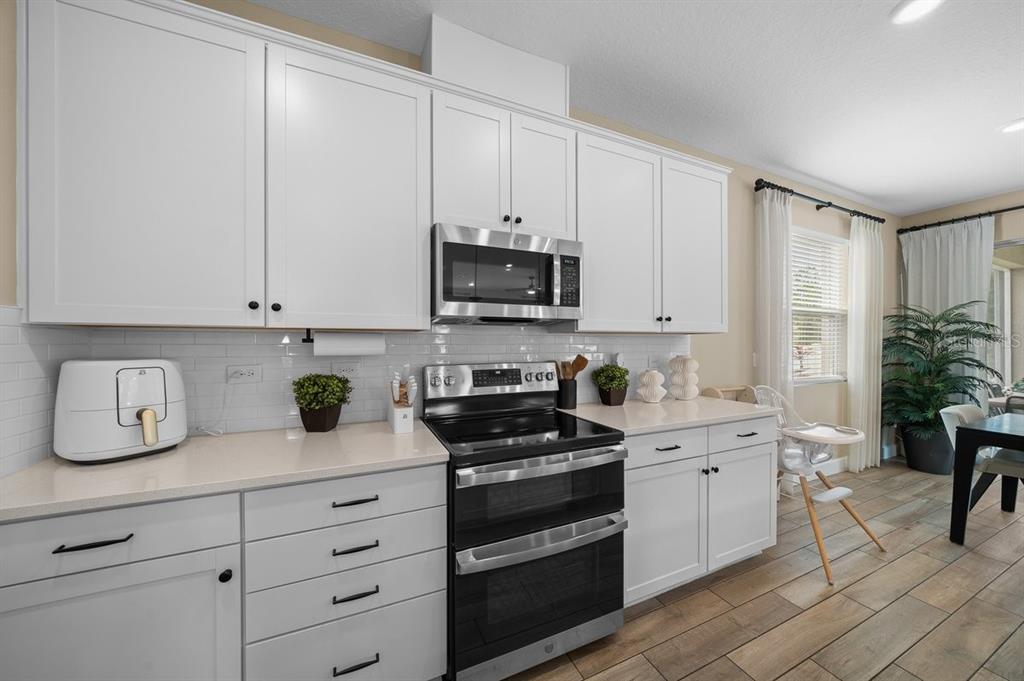 3916 Southern Vista Loop St. Cloud, FL 34772 - Photo 8 of 50 a kitchen with white cabinets and appliances