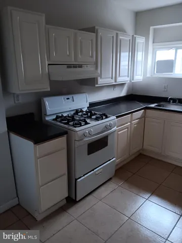 a stove top oven sitting inside of a kitchen