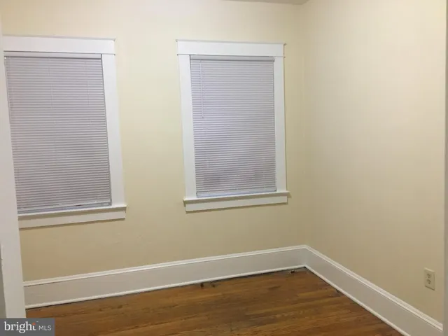 a view of a small space with wooden floor and a window
