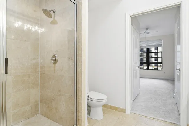 a bathroom with a granite countertop shower a toilet and a sink