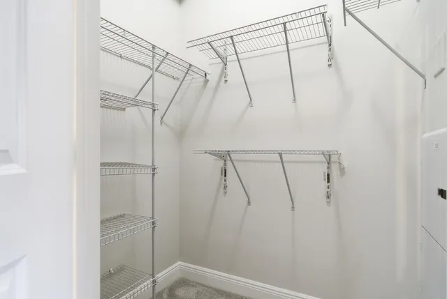 a view of walk in closet with clothes