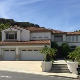 a view of the house with a yard and potted plants