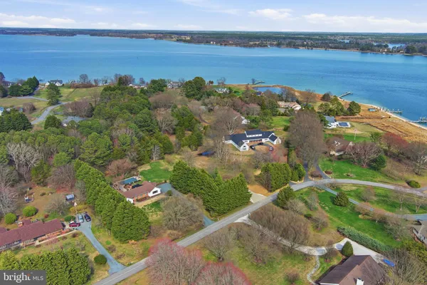 an aerial view of lake residential house with outdoor space and trees around