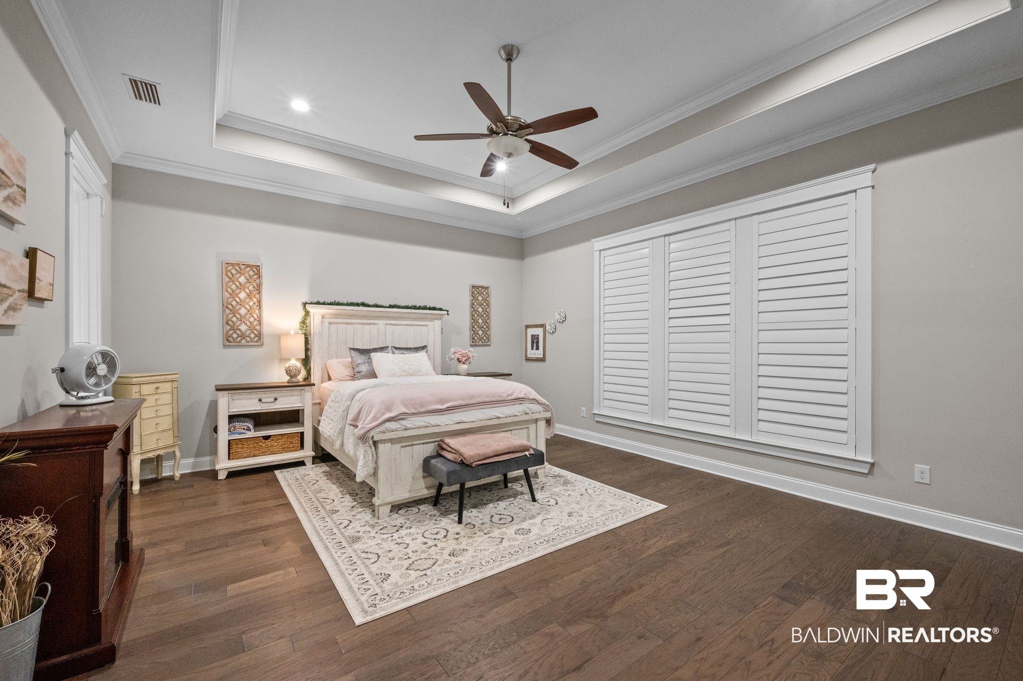 32194 Badger Court Daphne, AL 36527 - Photo 21 of 49 Bedroom with crown molding, ceiling fan, dark wood finished floors, and a tray ceiling