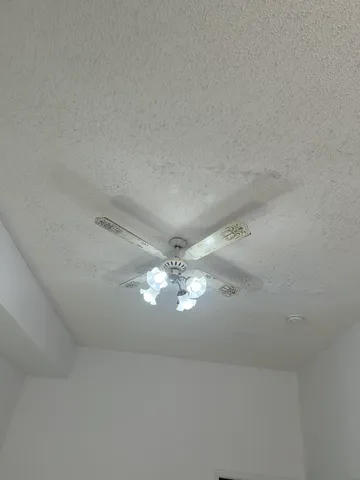 a view of a chandelier fan and fire place