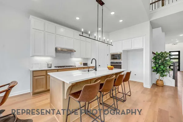 a kitchen with stainless steel appliances granite countertop a stove a sink dishwasher and a refrigerator with wooden floor