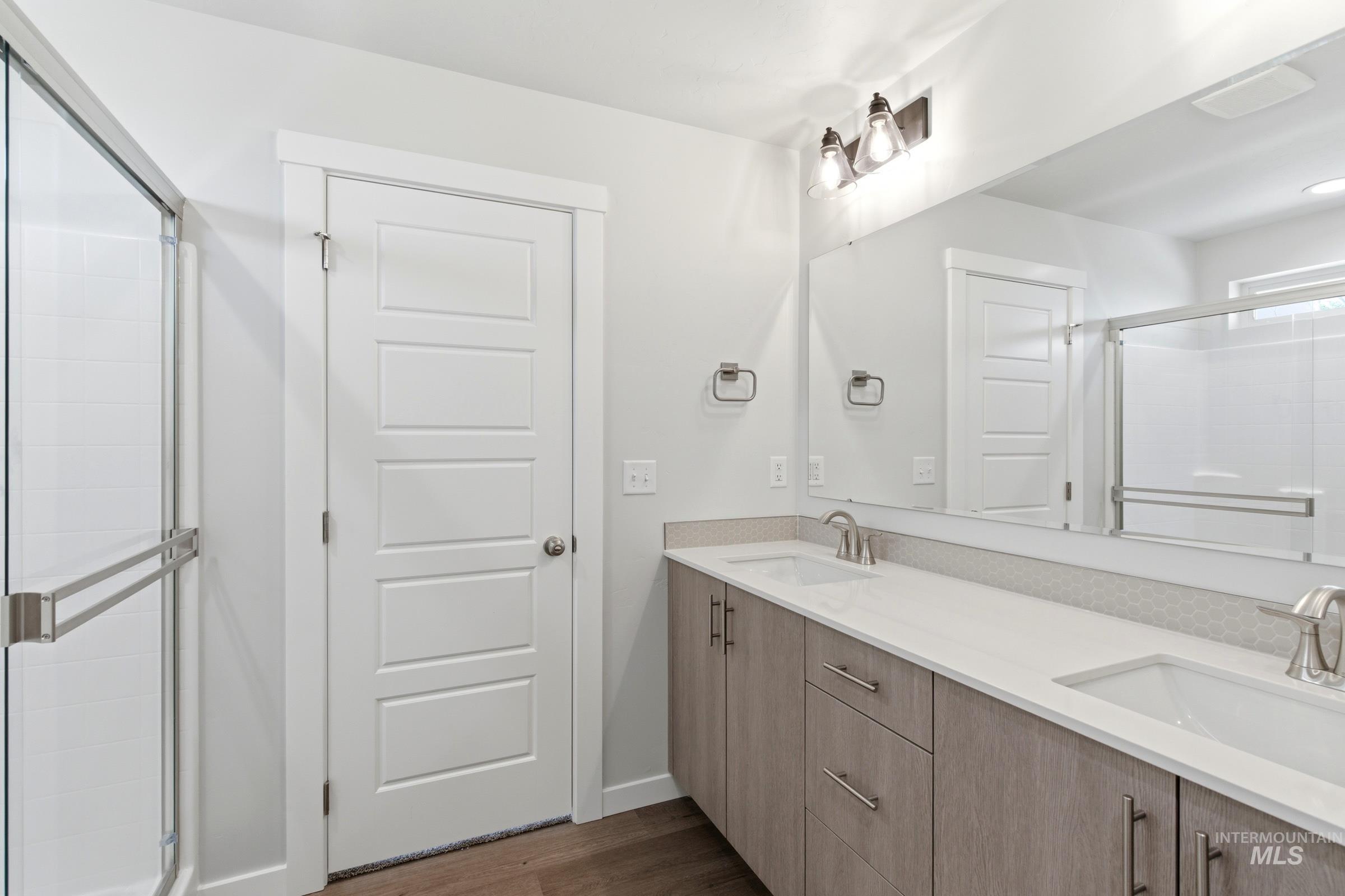 12829 Decatur Street Nampa, ID 83651 - Photo 32 of 33 Dual vanity with light wood-finish cabinetry, white countertops, and undermount sinks