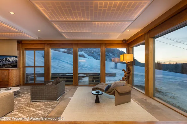 a living room with furniture floor to ceiling window and table