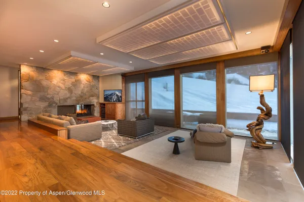 a living room with furniture large window and flat screen tv