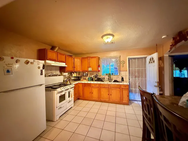 a kitchen with a refrigerator and a stove top oven