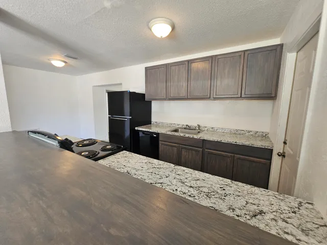 a kitchen with a stove a refrigerator and a sink