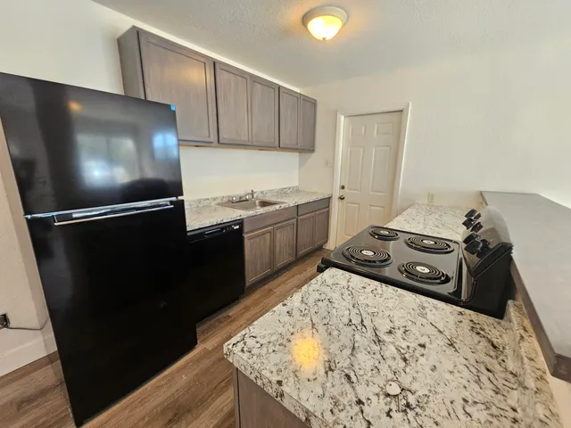 a kitchen with a refrigerator and a stove top oven