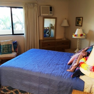 1032 South Kihei Road, Unit A203 Kihei, HI 96753 - Photo 5 of 13 a bedroom with a bed and dresser with mirror
