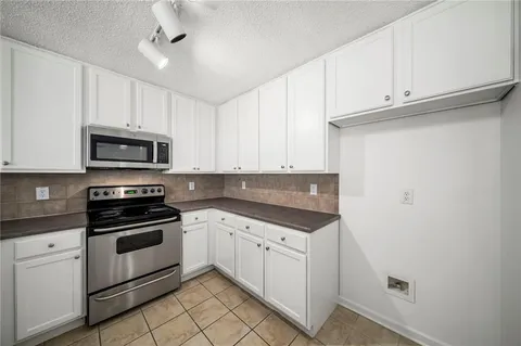 a kitchen with white cabinets stainless steel appliances and sink