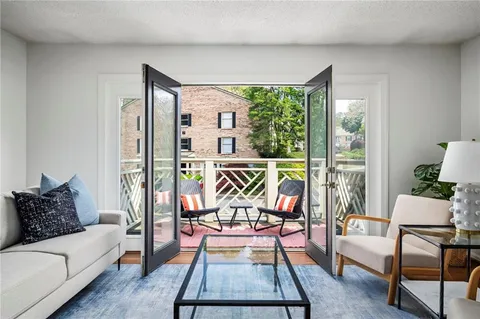 a living room with furniture and a floor to ceiling window