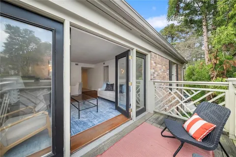 a view of a balcony with furniture and floor to ceiling window