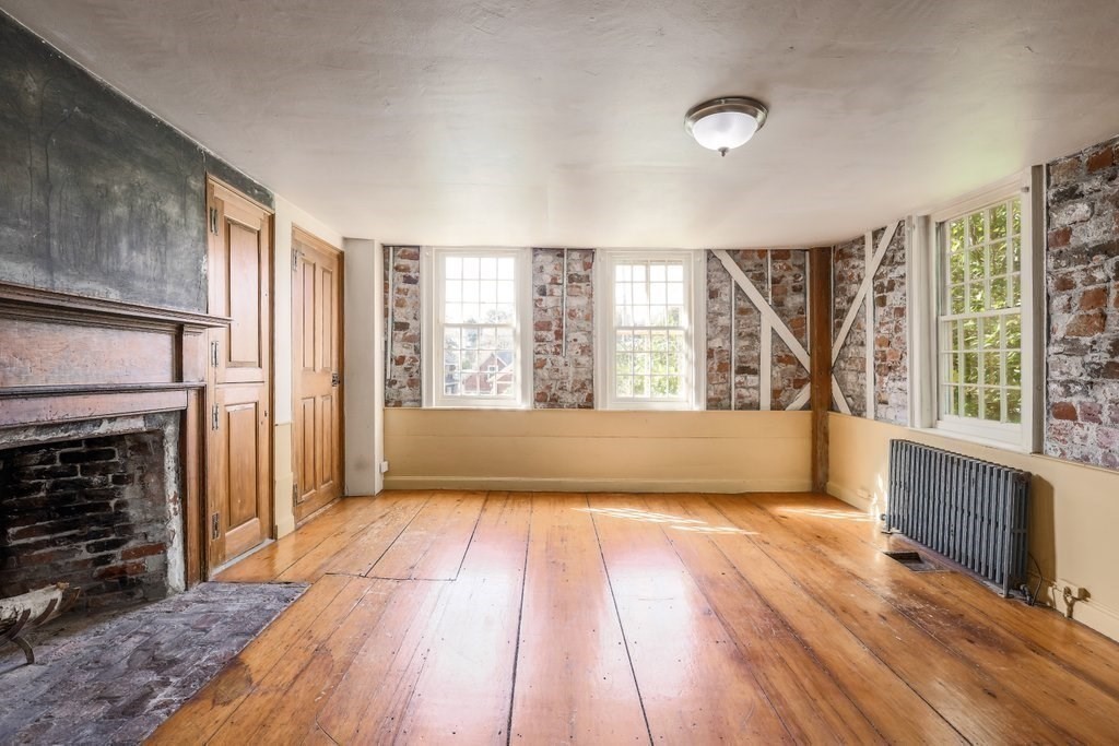 116 Spring Street Hull, MA 02045 - Photo 13 of 37 wooden floor in an empty room with a fireplace