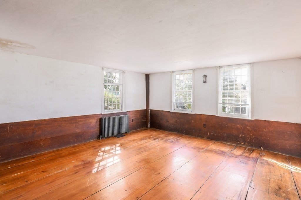 116 Spring Street Hull, MA 02045 - Photo 20 of 37 a view of an empty room with wooden floor and a window