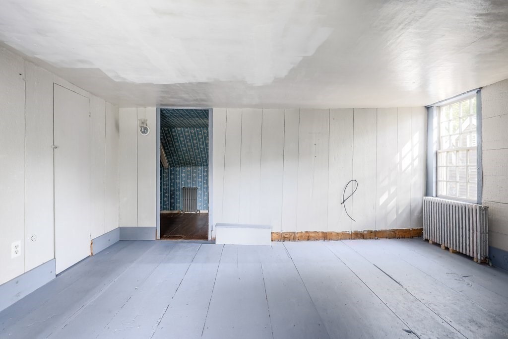 116 Spring Street Hull, MA 02045 - Photo 25 of 37 a view of an empty room with wooden floor and a window