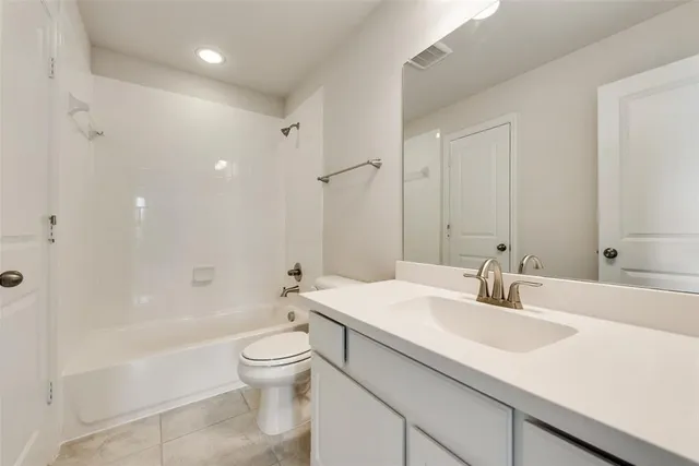a bathroom with a sink a toilet and a large mirror