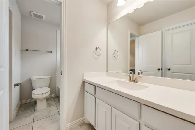 a bathroom with a sink a toilet a mirror and vanity