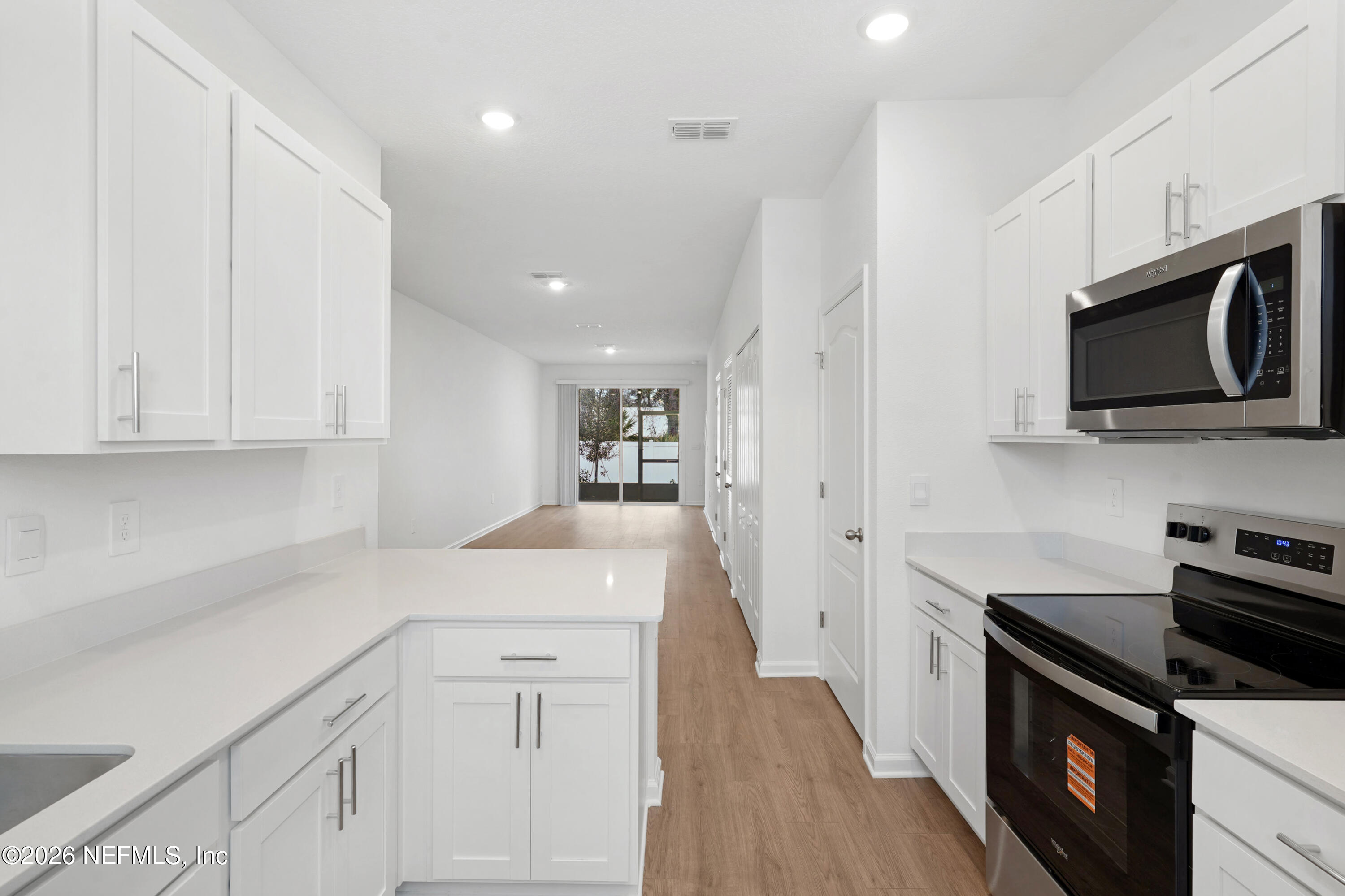 131 Palmetto Rdg Road St. Augustine, FL 32095 - Photo 5 of 26 a kitchen with stainless steel appliances white cabinets and a stove top oven