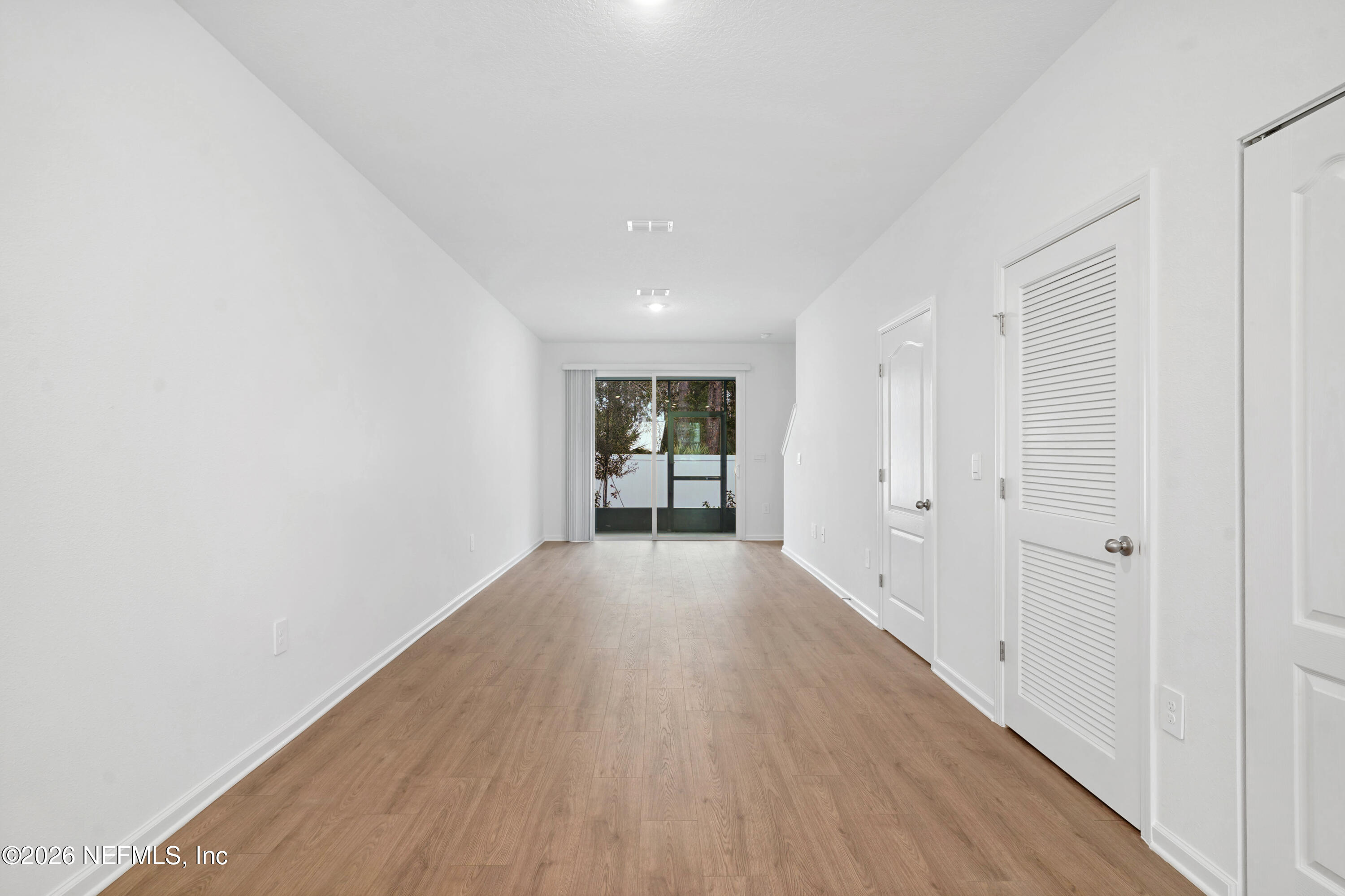 131 Palmetto Rdg Road St. Augustine, FL 32095 - Photo 7 of 26 a view of a hallway with wooden floor and a ceiling fan