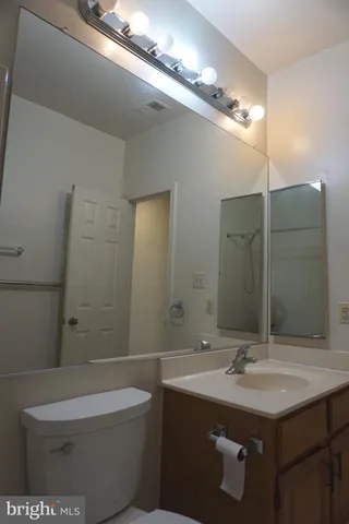 a bathroom with a sink a toilet a mirror and shower