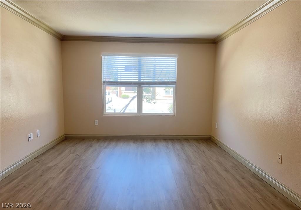 8101 West Flamingo Road, Unit 1082 Las Vegas, NV 89147 - Photo 5 of 23 Natural light illuminates the interior, highlighting the durable, low-maintenance flooring and classic crown molding.
