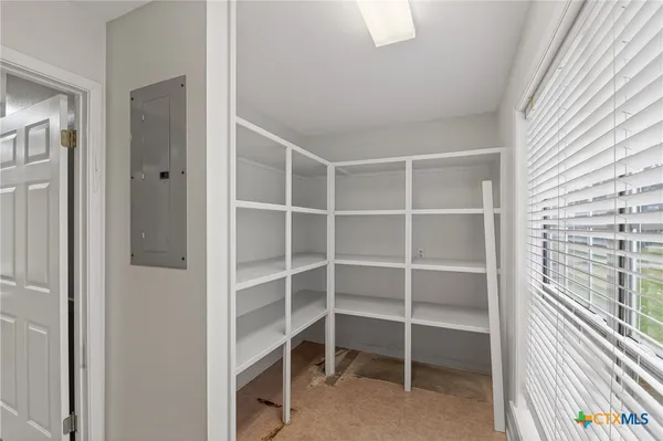 an empty room with windows and fan