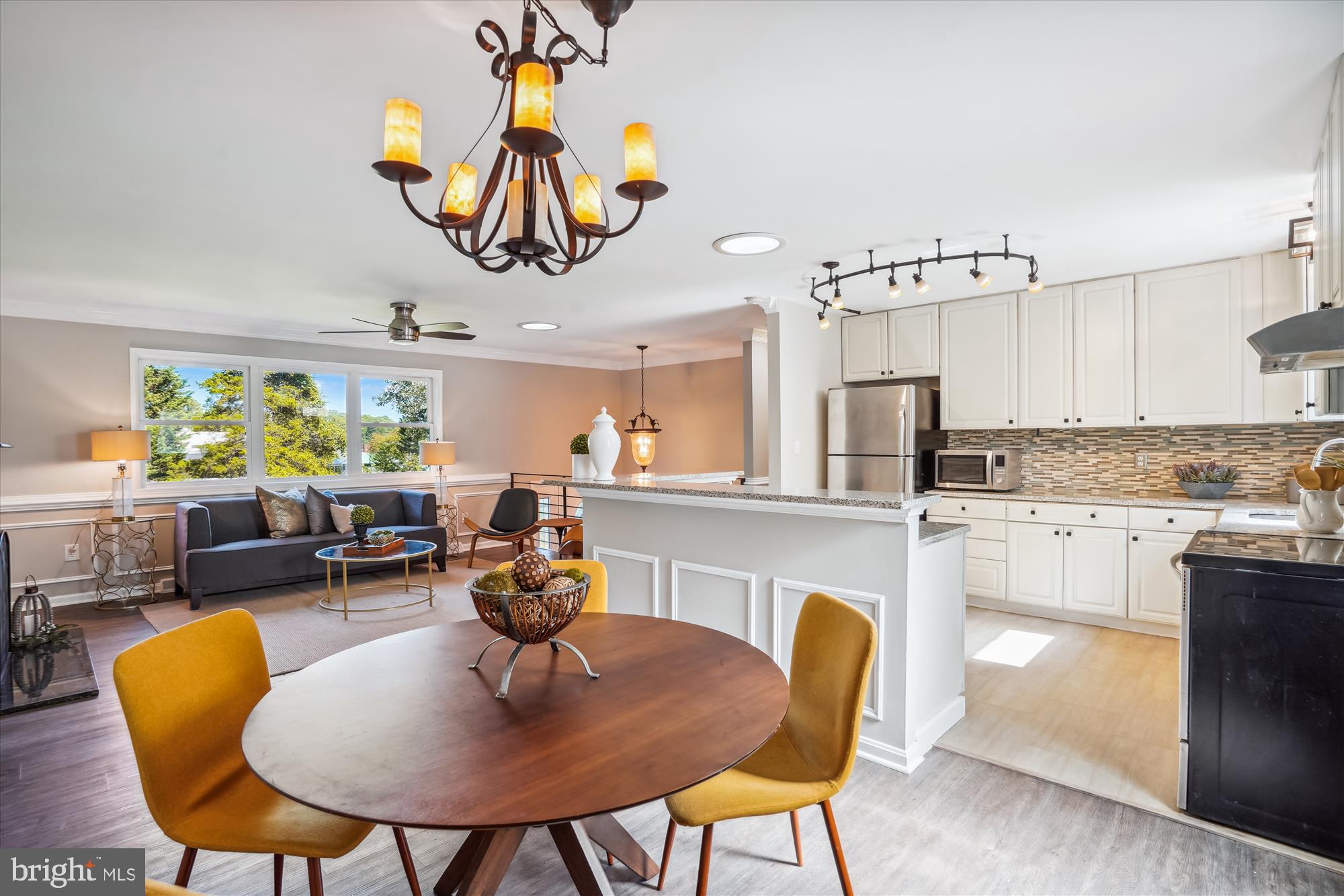 5742 Rolling Road Burke, VA 22015 - Photo 22 of 53 a kitchen with stainless steel appliances granite countertop a dining table chairs and a refrigerator